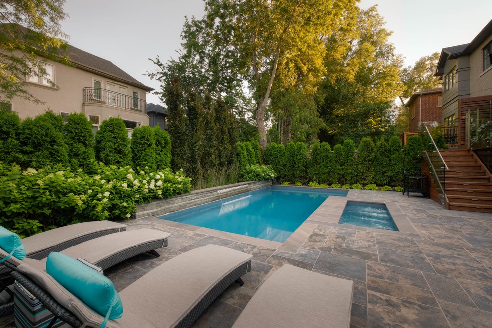 Diseño de piscinas y jacuzzis clásicos renovados pequeños rectangulares en patio trasero con adoquines de piedra natural