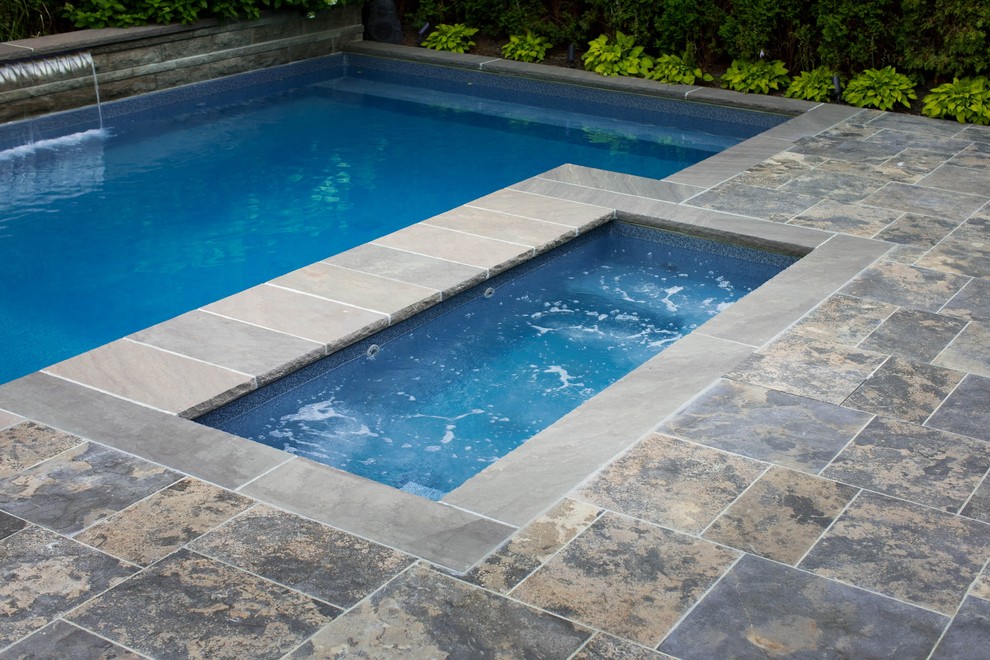Стильный дизайн: маленький прямоугольный бассейн на заднем дворе в стиле неоклассика (современная классика) с джакузи и покрытием из каменной брусчатки для на участке и в саду - последний тренд