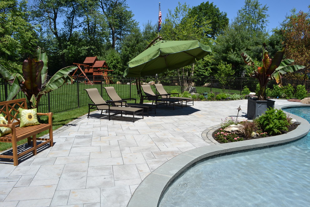 Ispirazione per una grande piscina minimalista personalizzata dietro casa con fontane e pavimentazioni in cemento