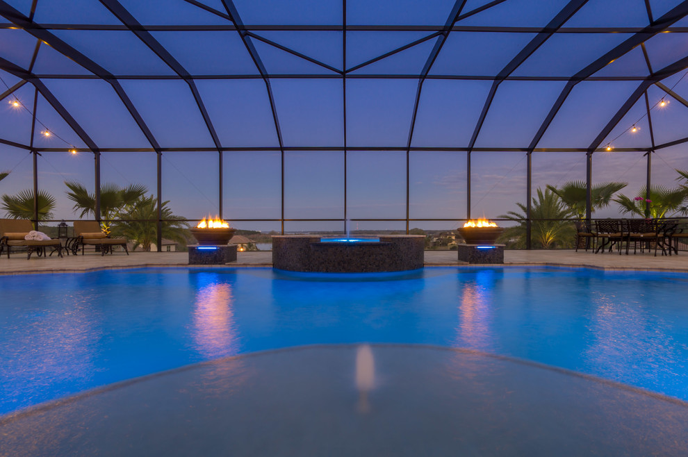 Idee per un'ampia piscina coperta mediterranea personalizzata con una vasca idromassaggio e pavimentazioni in pietra naturale