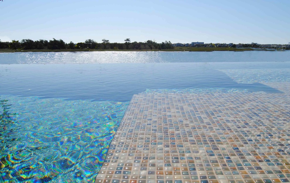 Idée de décoration pour une piscine à débordement et arrière design rectangle avec du carrelage.