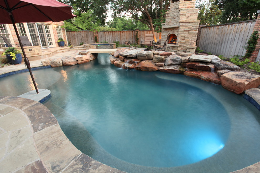 Пример оригинального дизайна: большой естественный бассейн в форме фасоли на заднем дворе в стиле рустика с джакузи и покрытием из каменной брусчатки