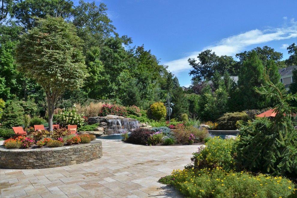 Example of a large island style backyard custom-shaped pool fountain design in New York