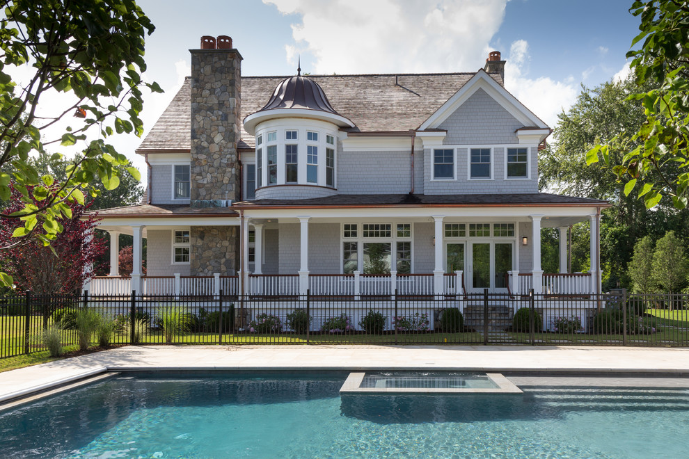 Ispirazione per una grande piscina chic rettangolare dietro casa con pavimentazioni in pietra naturale
