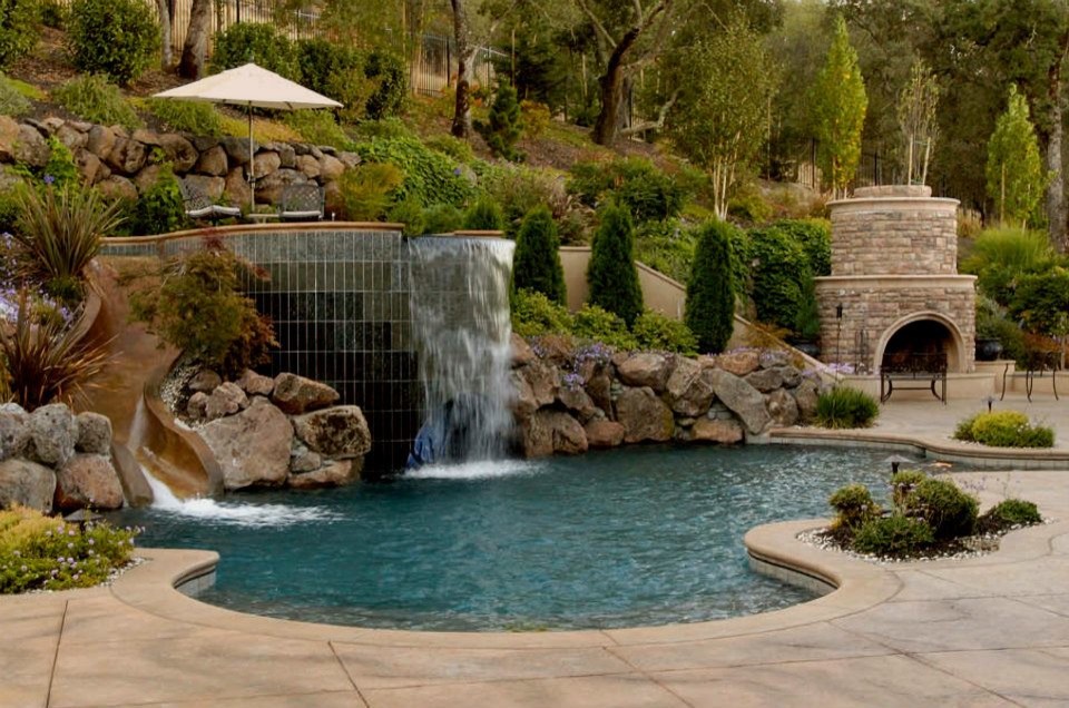 На фото: большой бассейн произвольной формы на заднем дворе в классическом стиле с джакузи и покрытием из каменной брусчатки с