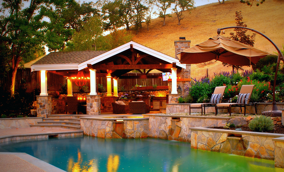 Foto di una grande piscina naturale chic personalizzata dietro casa con pavimentazioni in pietra naturale