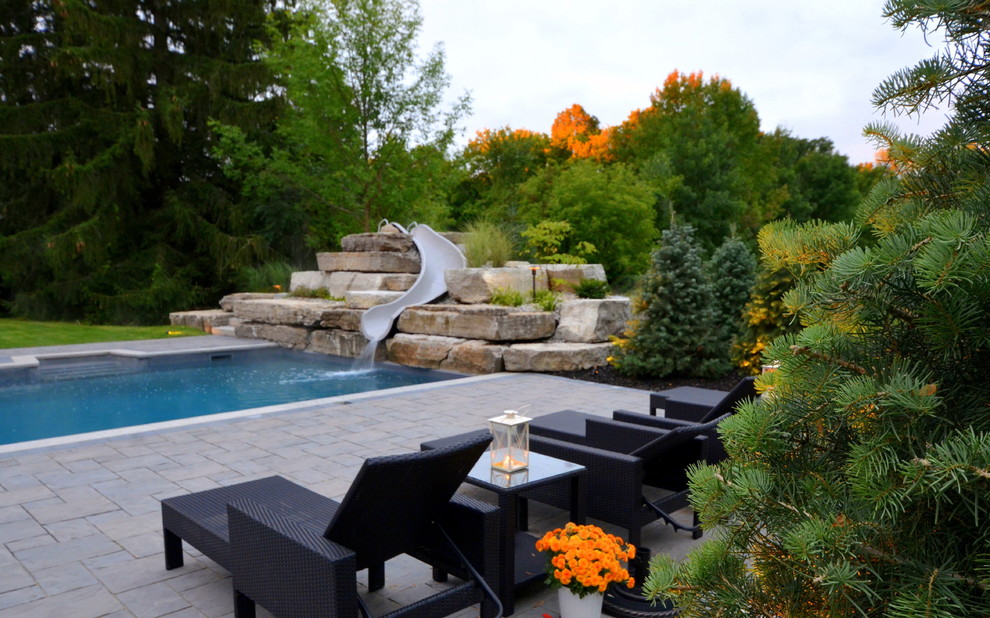 Moderner Pool hinter dem Haus in L-Form mit Wasserrutsche und Betonboden in Toronto