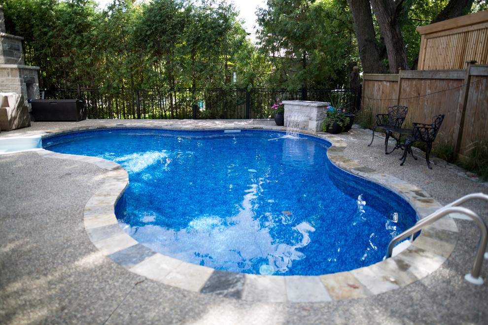 Ispirazione per una piscina tradizionale personalizzata di medie dimensioni e dietro casa con fontane e lastre di cemento
