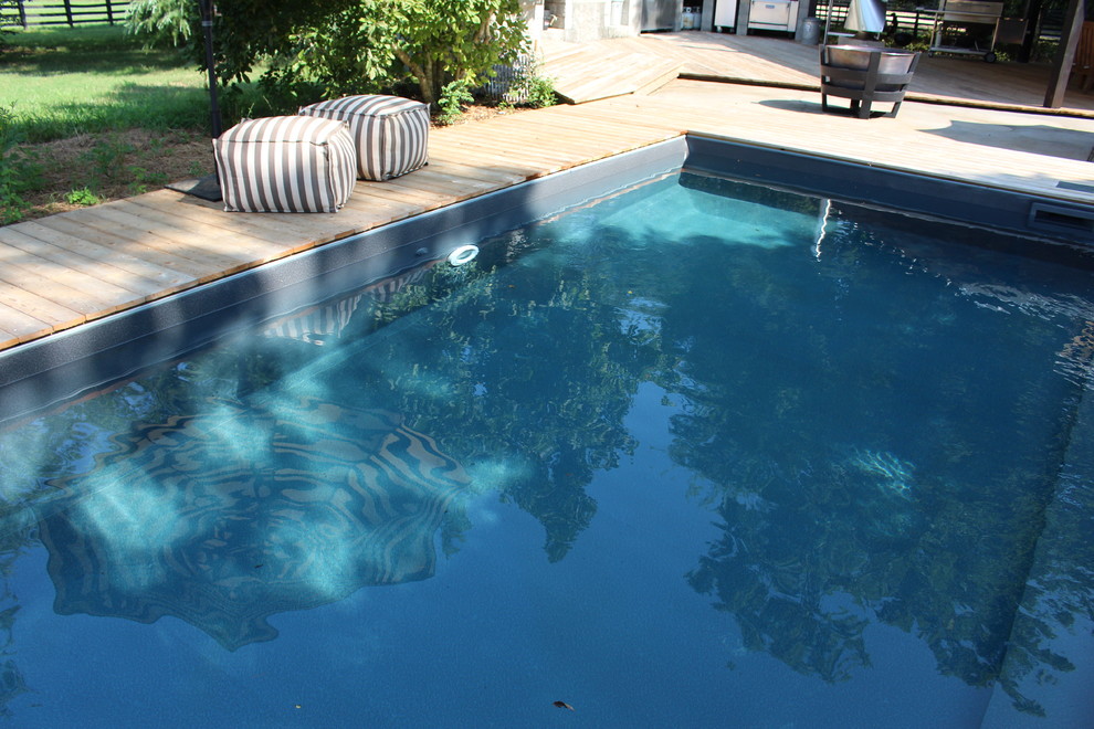 Foto de piscinas y jacuzzis naturales rústicos grandes en forma de L en patio trasero con entablado