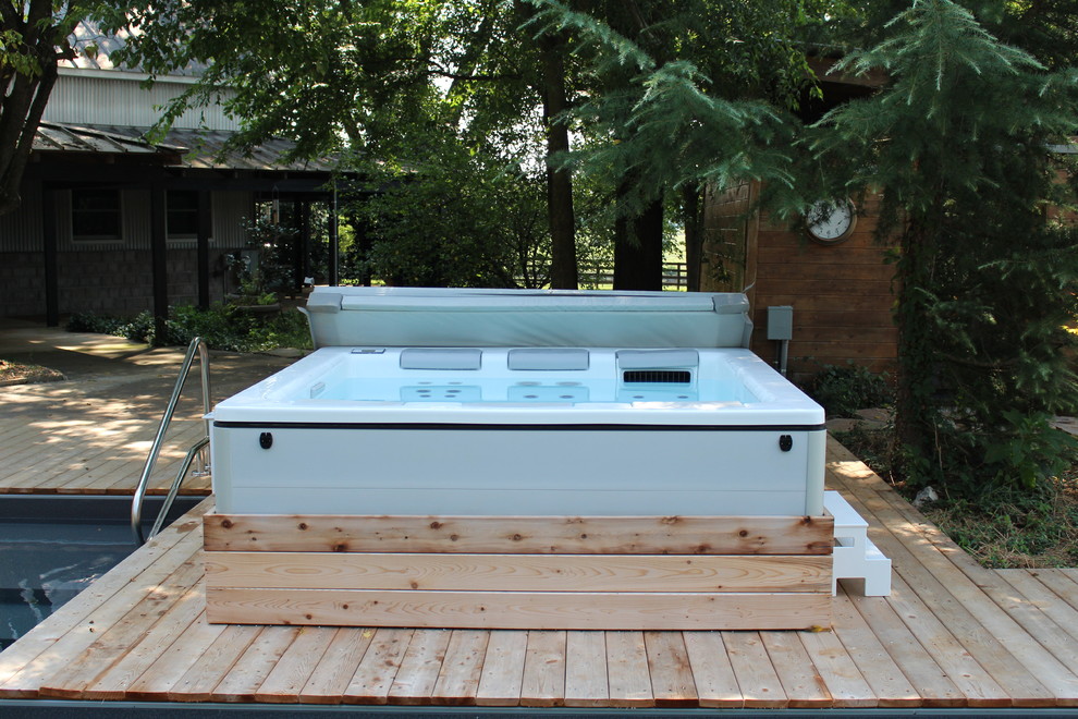 Идея дизайна: большой естественный, угловой бассейн на заднем дворе в стиле рустика с джакузи и настилом