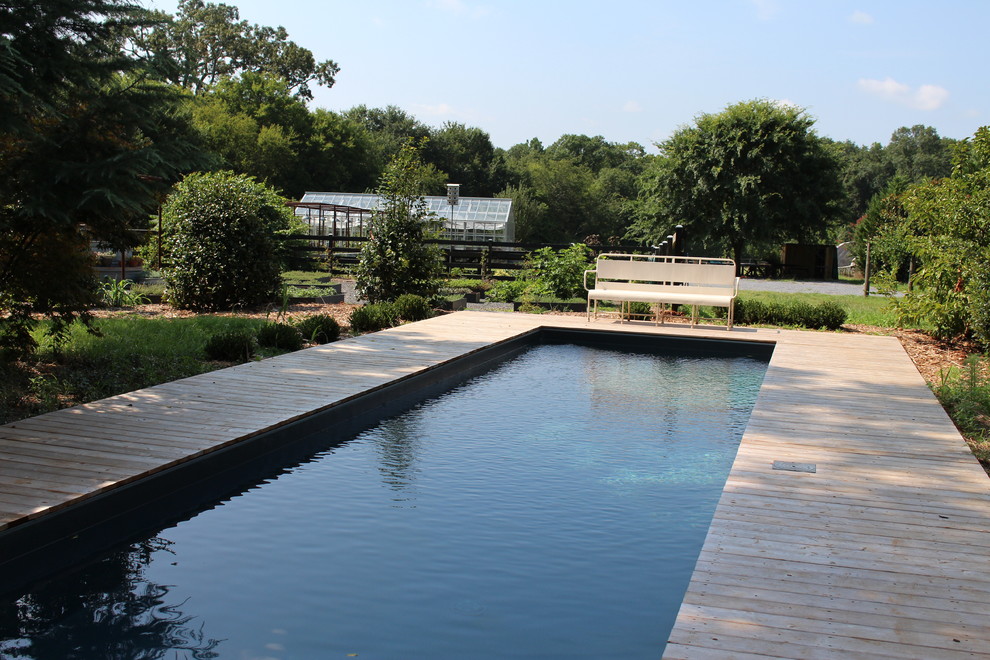 Ejemplo de piscinas y jacuzzis naturales rústicos grandes en forma de L en patio trasero con entablado