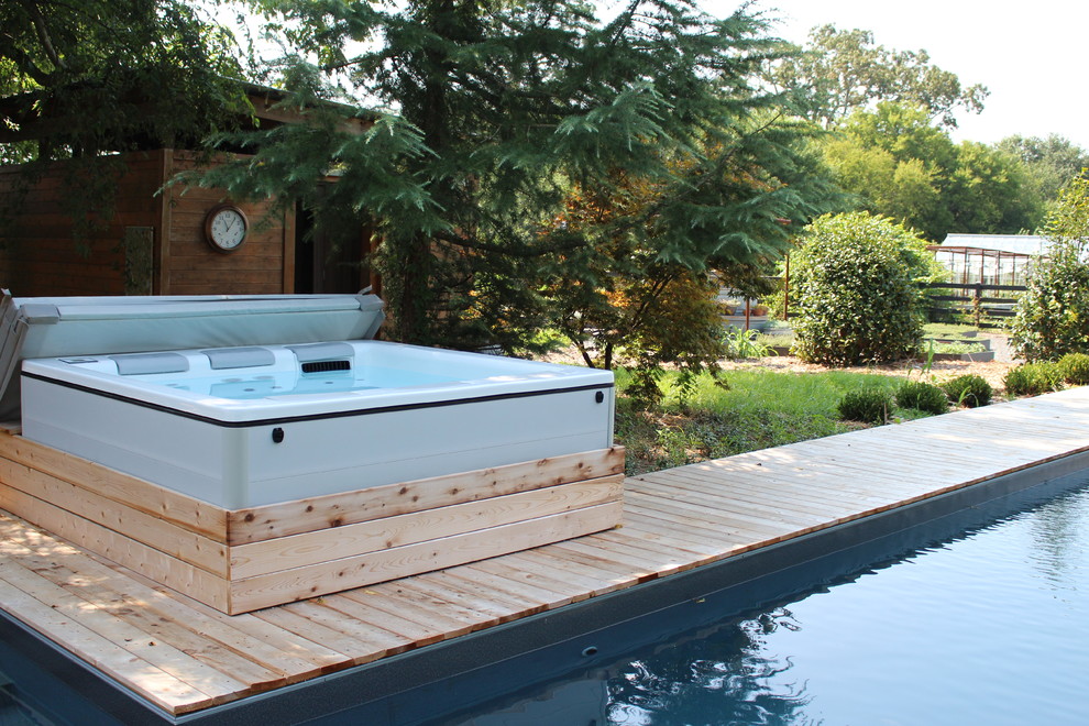 This is an example of a large rustic back l-shaped natural hot tub in Atlanta with decking.