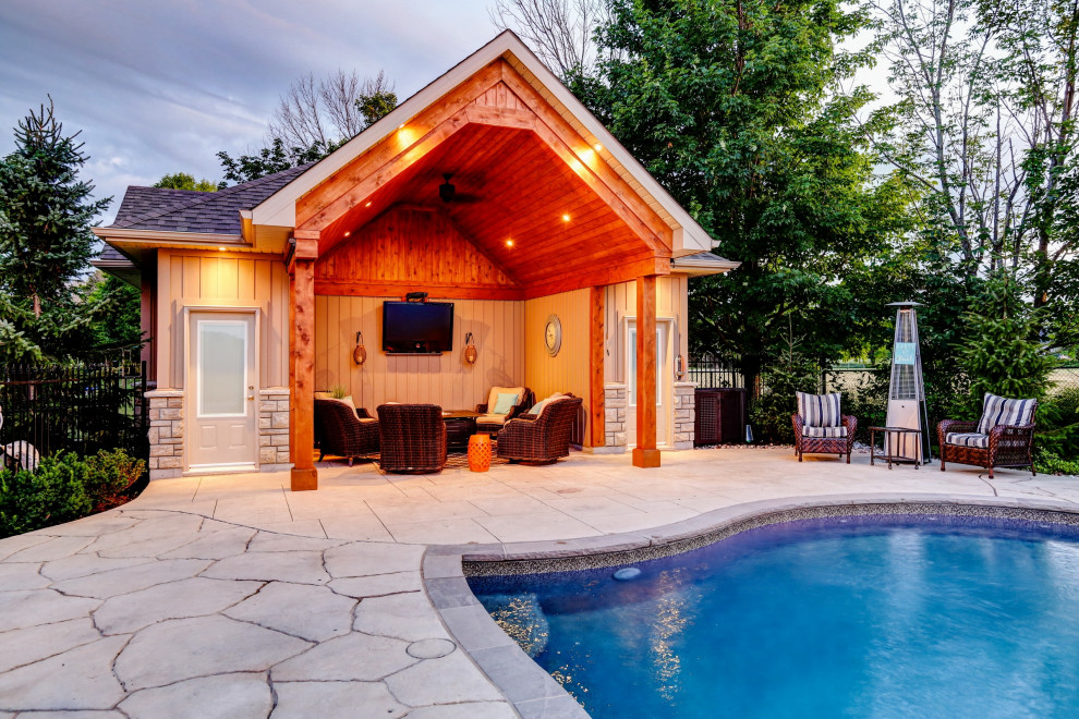 Cette image montre un grand Abris de piscine et pool houses arrière traditionnel sur mesure avec du béton estampé.