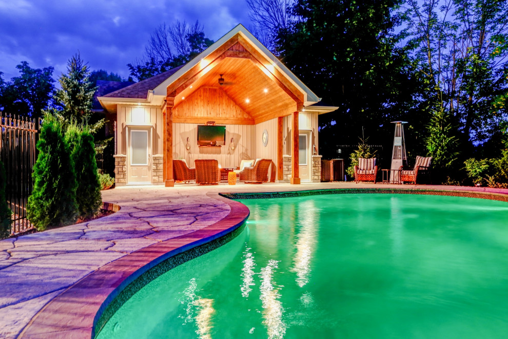 Exemple d'un grand Abris de piscine et pool houses arrière chic sur mesure avec du béton estampé.