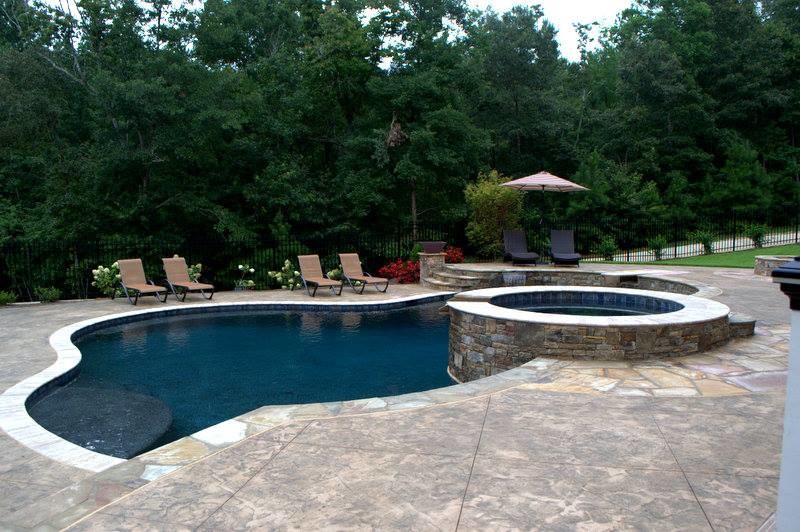 Foto di un'ampia piscina minimalista personalizzata dietro casa con una vasca idromassaggio