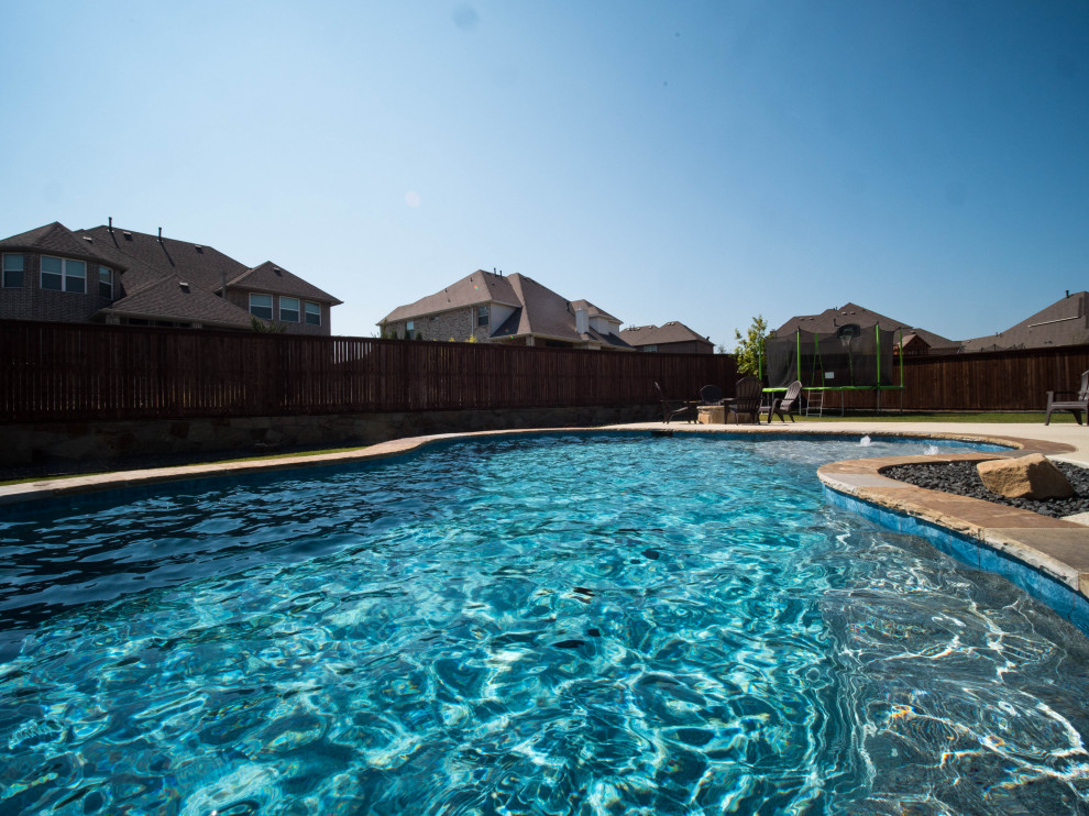 Example of a mid-sized southwest backyard concrete paver and custom-shaped natural pool landscaping design in Dallas