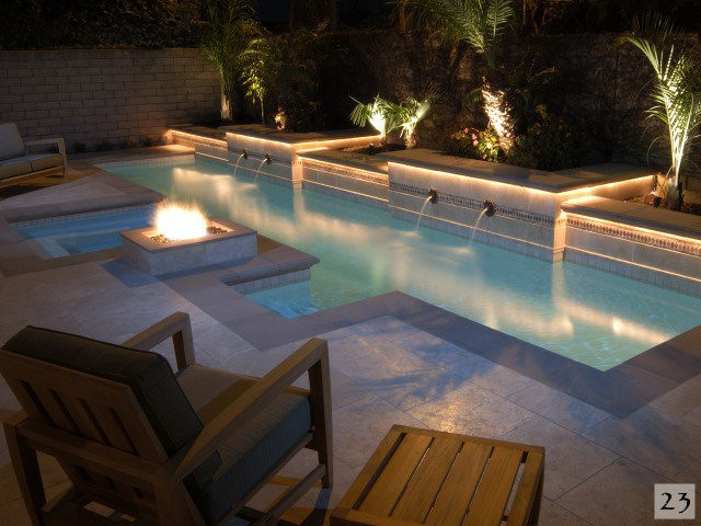 Ejemplo de piscina alargada mediterránea pequeña rectangular en patio trasero con suelo de baldosas