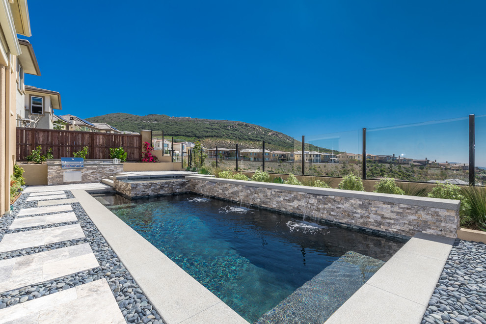 Diseño de piscina tradicional renovada pequeña a medida en patio trasero con adoquines de piedra natural