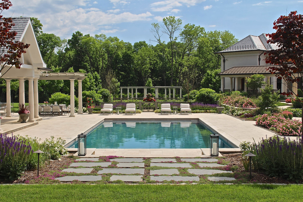 На фото: прямоугольный бассейн на заднем дворе в классическом стиле с