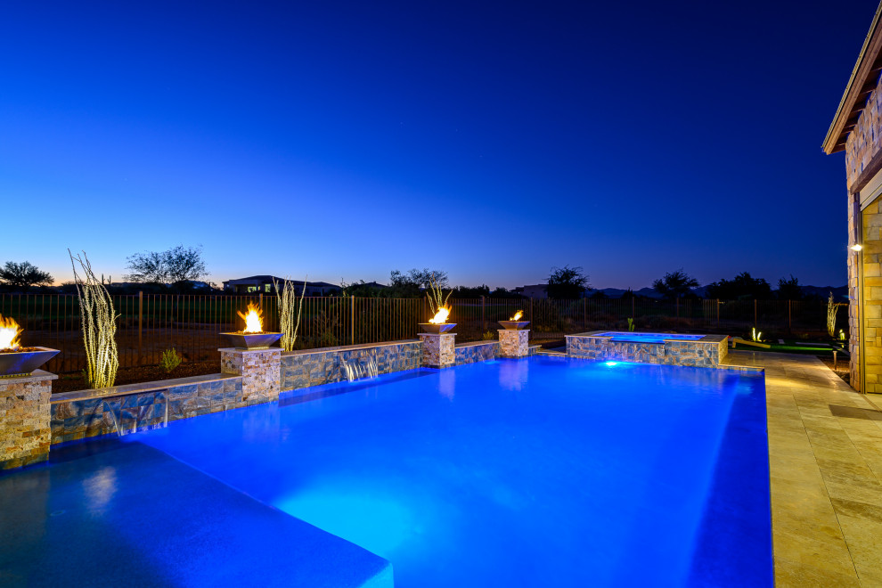 Diseño de piscina extra grande rectangular en patio trasero con adoquines de piedra natural