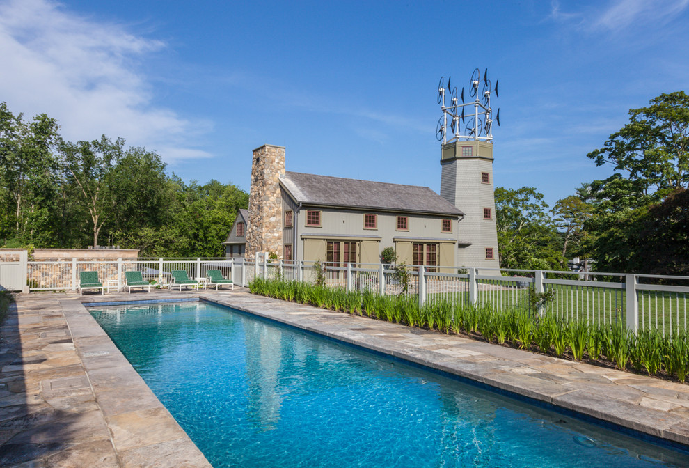 Imagen de piscina de estilo de casa de campo rectangular con adoquines de piedra natural