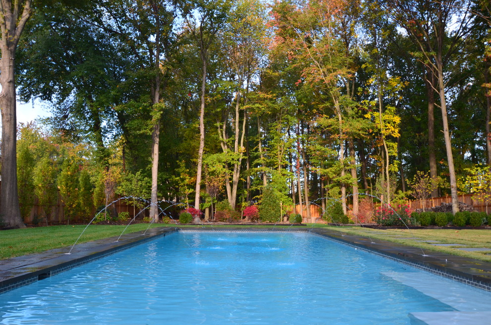 Стильный дизайн: большой прямоугольный, спортивный бассейн на заднем дворе в классическом стиле с покрытием из каменной брусчатки - последний тренд
