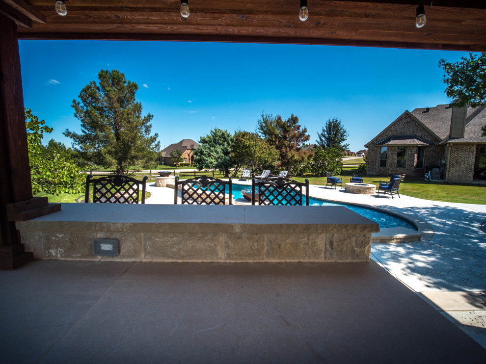 Inspiration for an expansive back custom shaped natural swimming pool in Dallas with with pool landscaping and concrete paving.