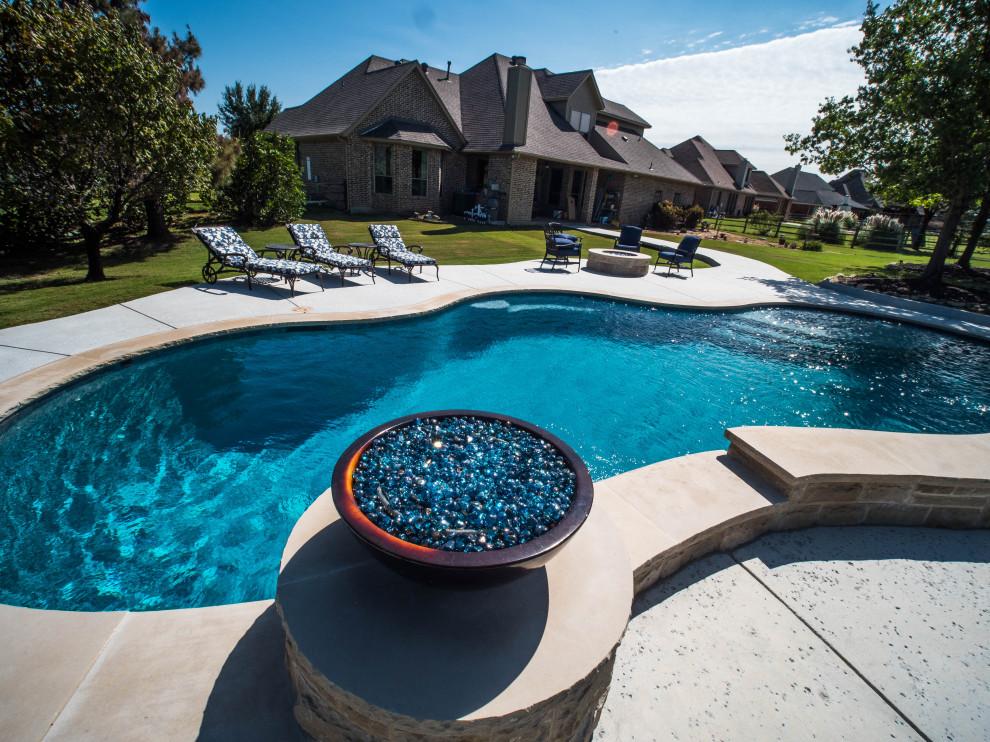 Pool landscaping - huge southwestern backyard concrete paver and custom-shaped natural pool landscaping idea in Dallas