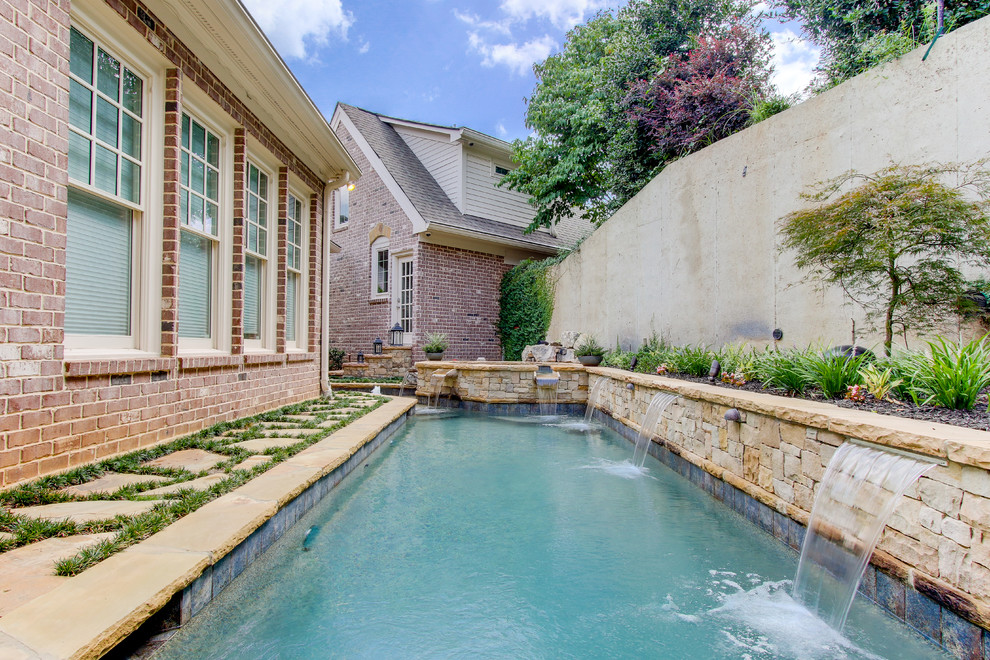 Immagine di una piscina monocorsia boho chic rettangolare di medie dimensioni e dietro casa con una vasca idromassaggio e pavimentazioni in pietra naturale