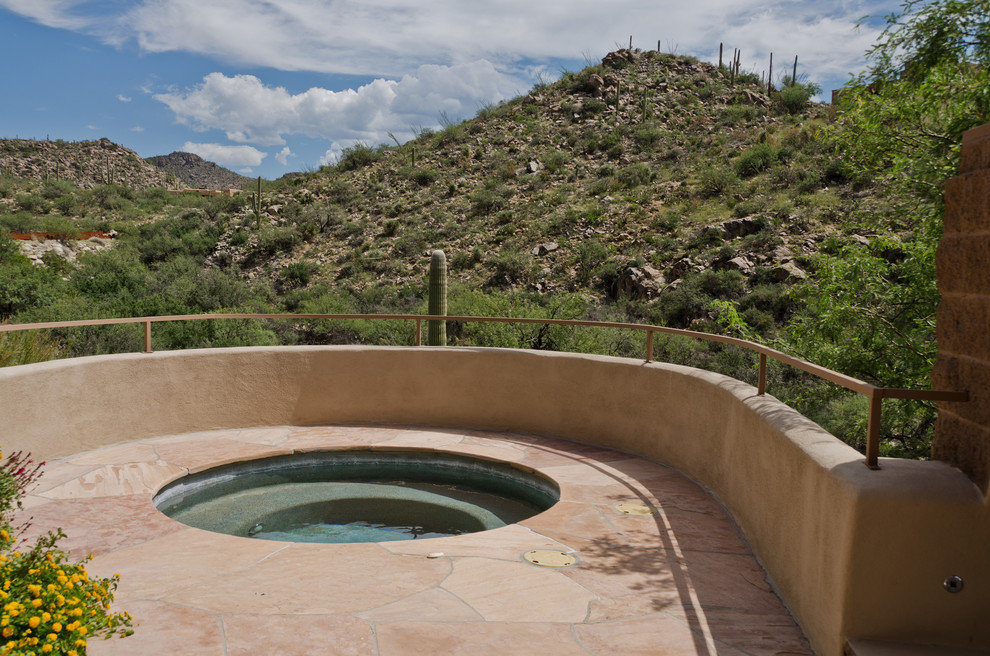Idee per una piscina a sfioro infinito american style rettangolare di medie dimensioni e dietro casa con una vasca idromassaggio e pavimentazioni in pietra naturale