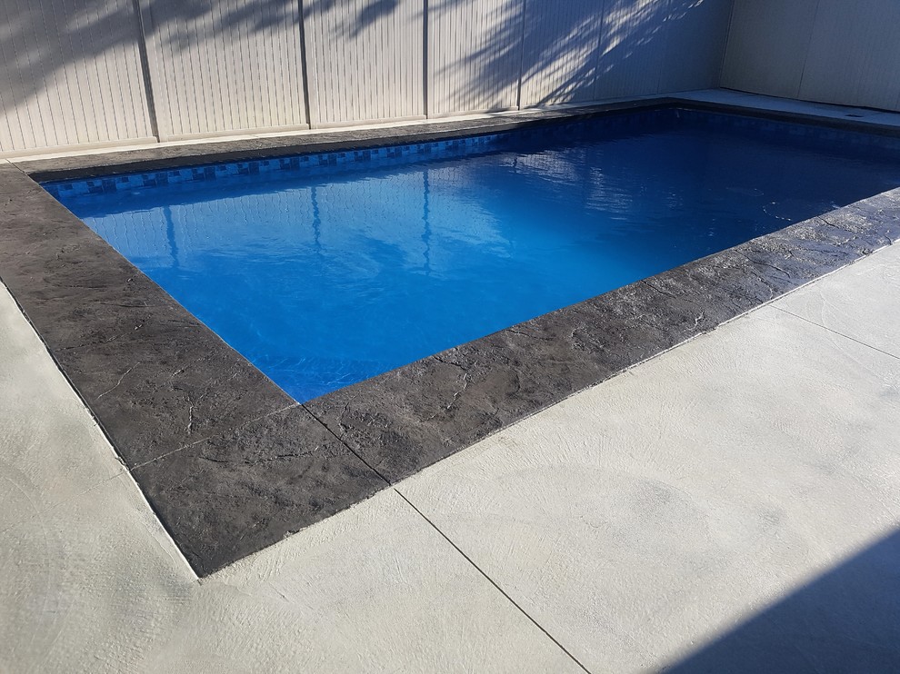 Foto di una piccola piscina chic rettangolare dietro casa con pavimentazioni in cemento