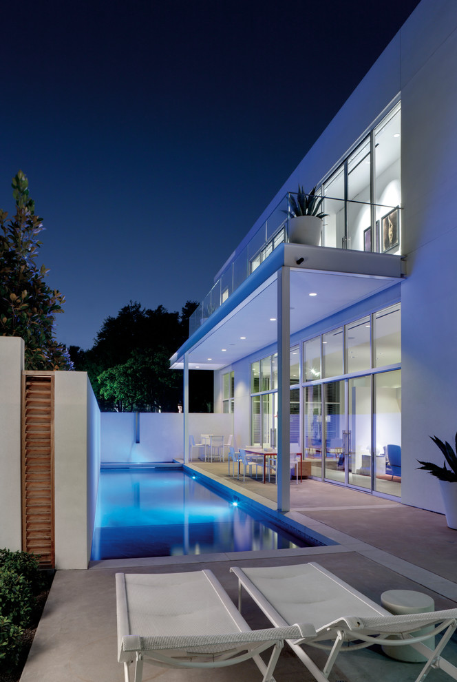 Photo of a contemporary rectangular swimming pool in Dallas with concrete slabs.