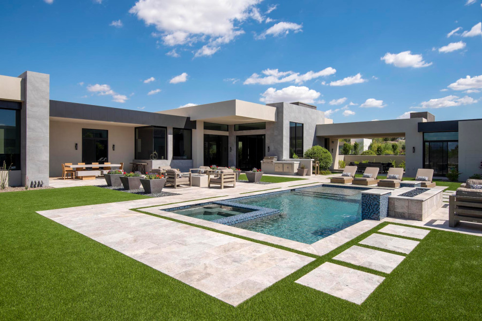 Идея дизайна: большой прямоугольный бассейн на заднем дворе в стиле модернизм с джакузи и покрытием из каменной брусчатки