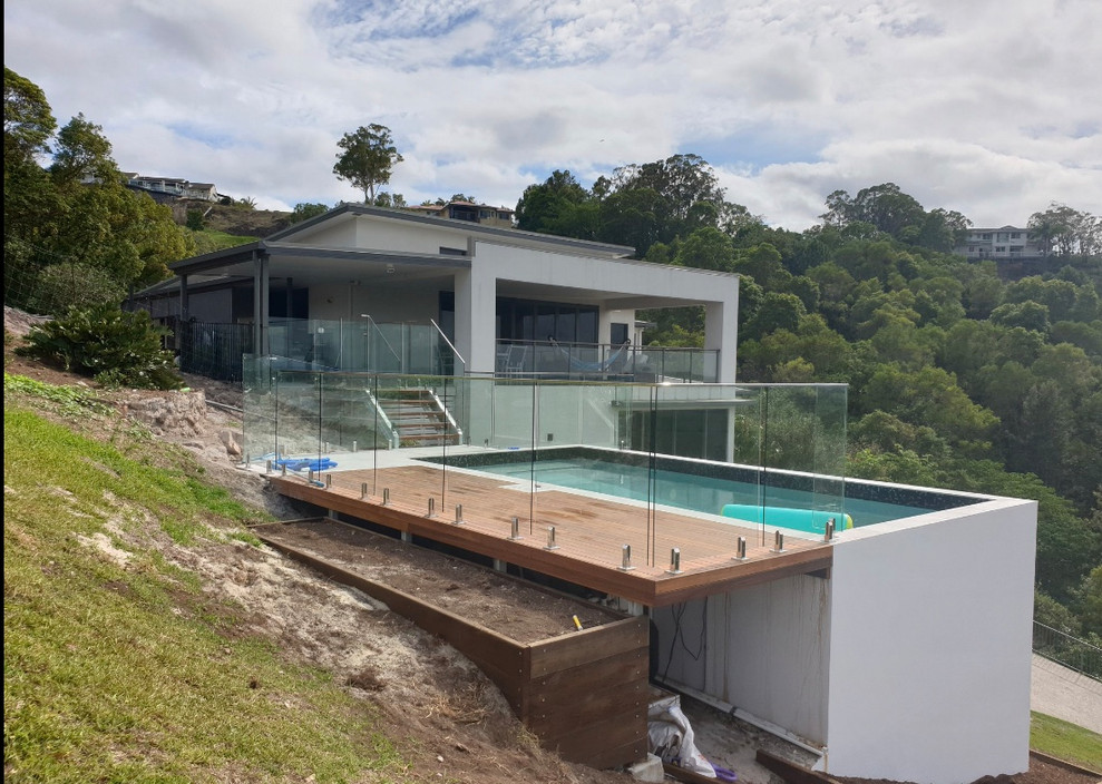 Mid-sized trendy front yard rectangular aboveground pool photo in Sunshine Coast with decking