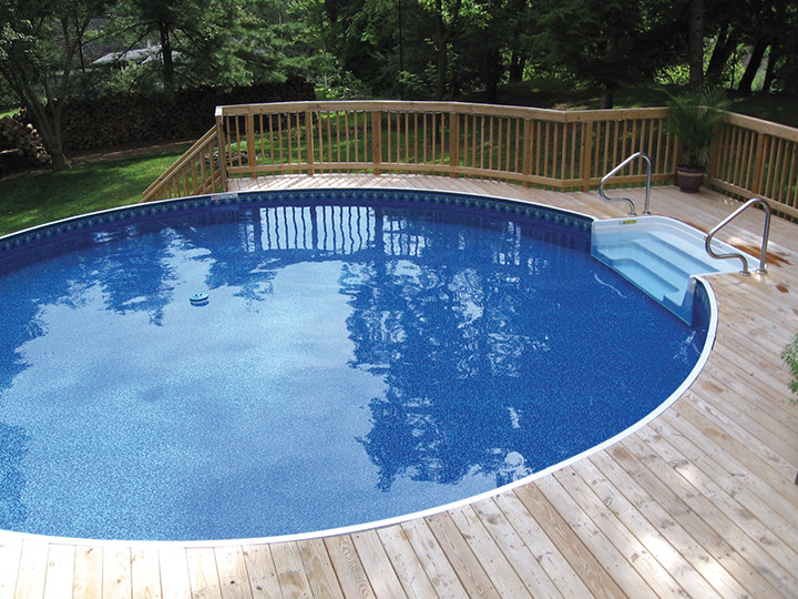 Imagen de piscina tradicional de tamaño medio redondeada en patio trasero con entablado