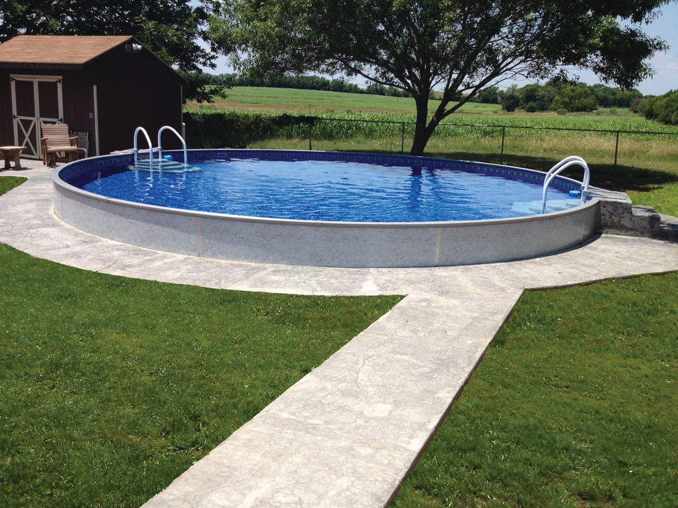 Foto de piscina elevada actual de tamaño medio redondeada en patio trasero con losas de hormigón