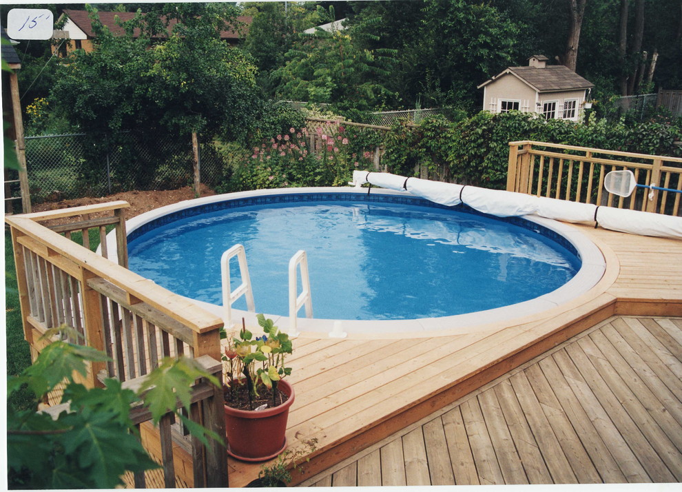 Modelo de piscina elevada tradicional de tamaño medio redondeada en patio trasero con entablado