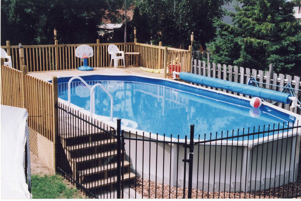 Imagen de piscina elevada clásica de tamaño medio redondeada en patio trasero con entablado