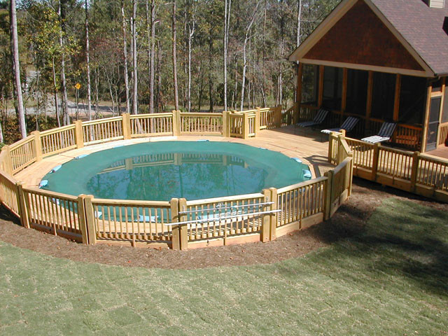Ejemplo de piscina alargada tradicional grande redondeada en patio trasero con entablado