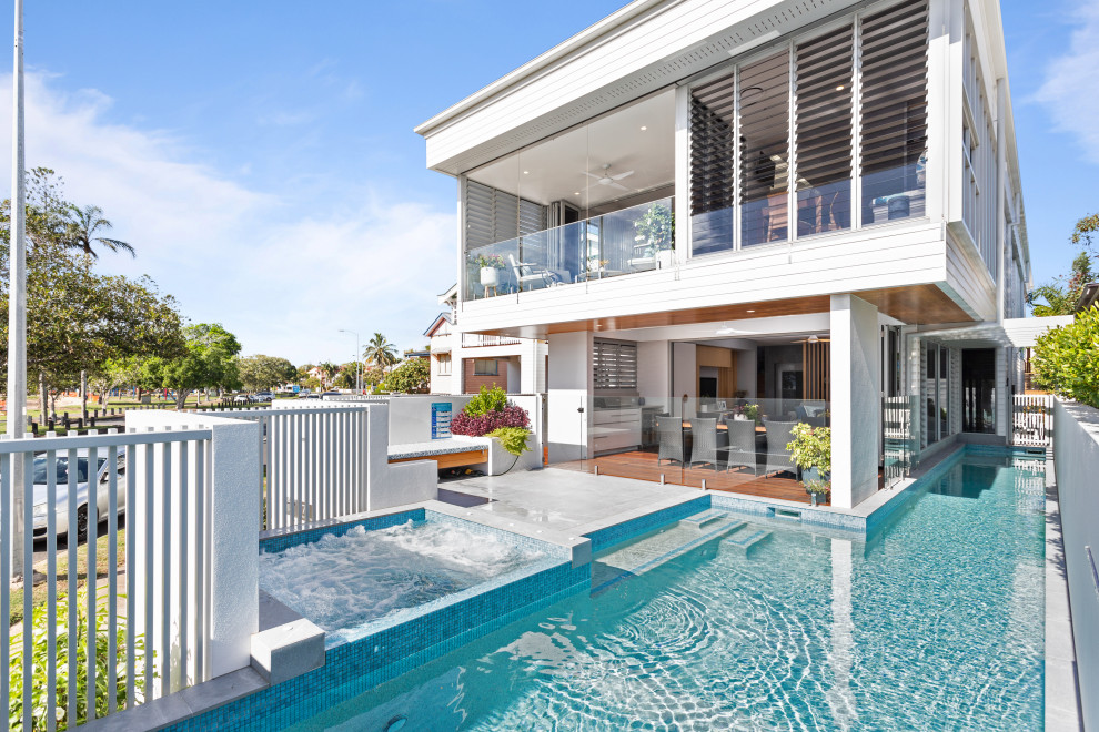 Foto di una piscina fuori terra costiera personalizzata davanti casa con una vasca idromassaggio e piastrelle