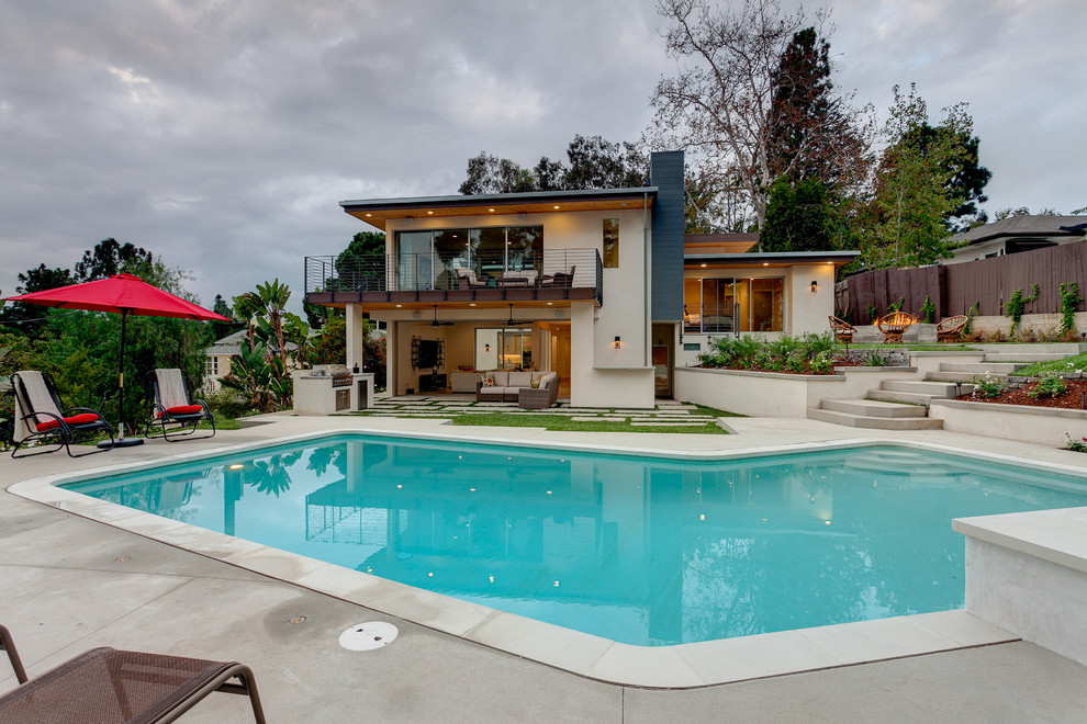 Ispirazione per una grande piscina monocorsia contemporanea a "L" dietro casa con lastre di cemento