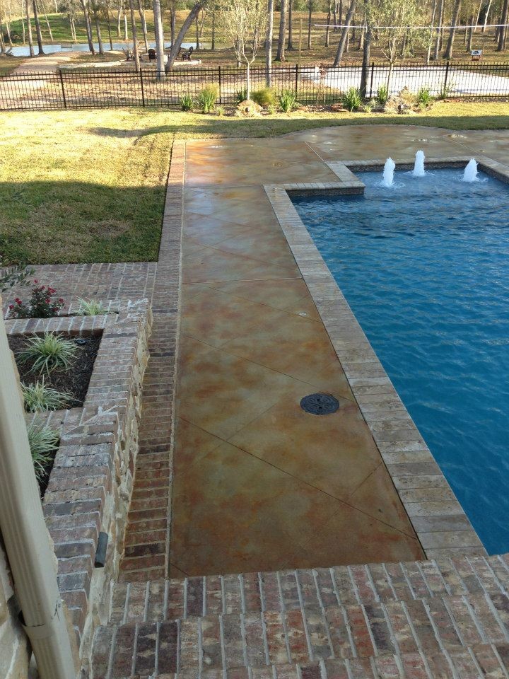 Diseño de piscina con fuente alargada actual de tamaño medio rectangular en patio trasero con adoquines de ladrillo