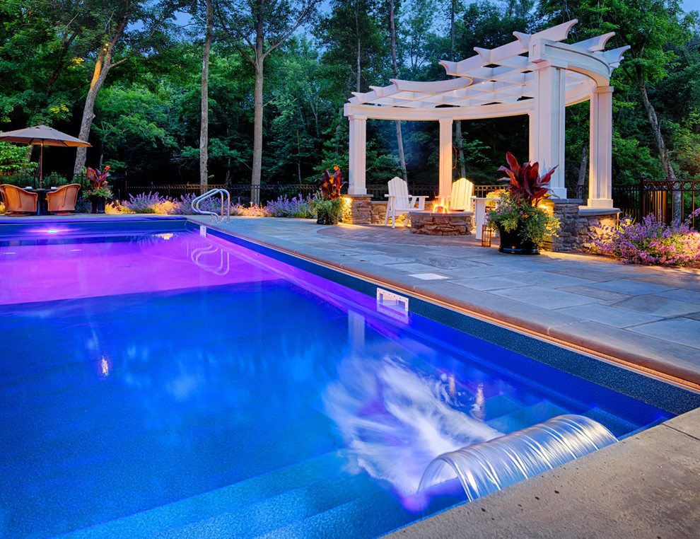 Imagen de piscina con fuente clásica extra grande rectangular en patio trasero con adoquines de piedra natural