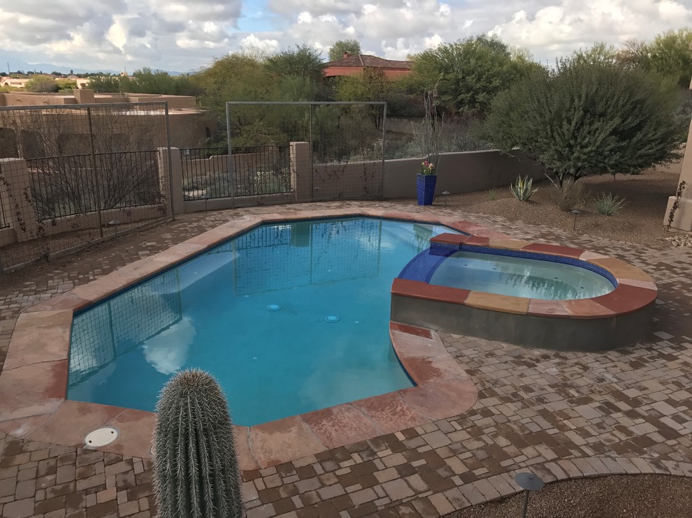 Diseño de piscinas y jacuzzis alargados de estilo americano grandes a medida en patio trasero con adoquines de ladrillo