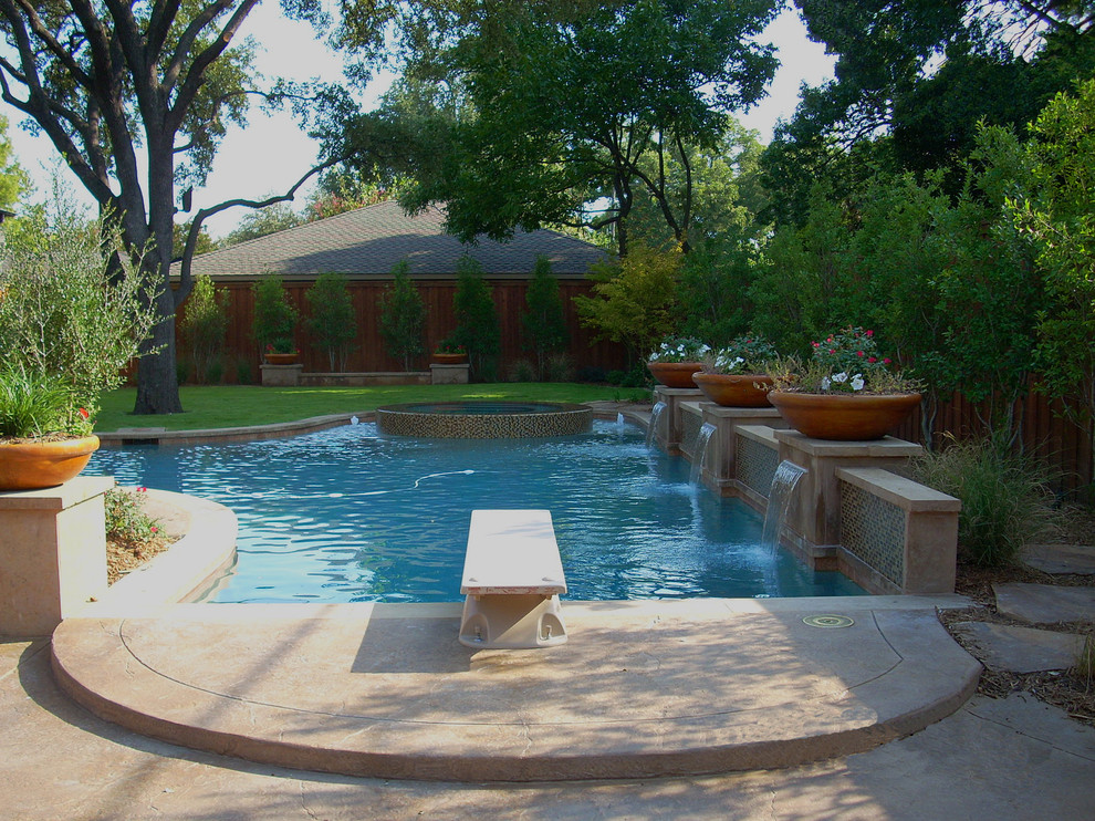 Idee per una grande piscina monocorsia design personalizzata dietro casa con una vasca idromassaggio e pavimentazioni in cemento