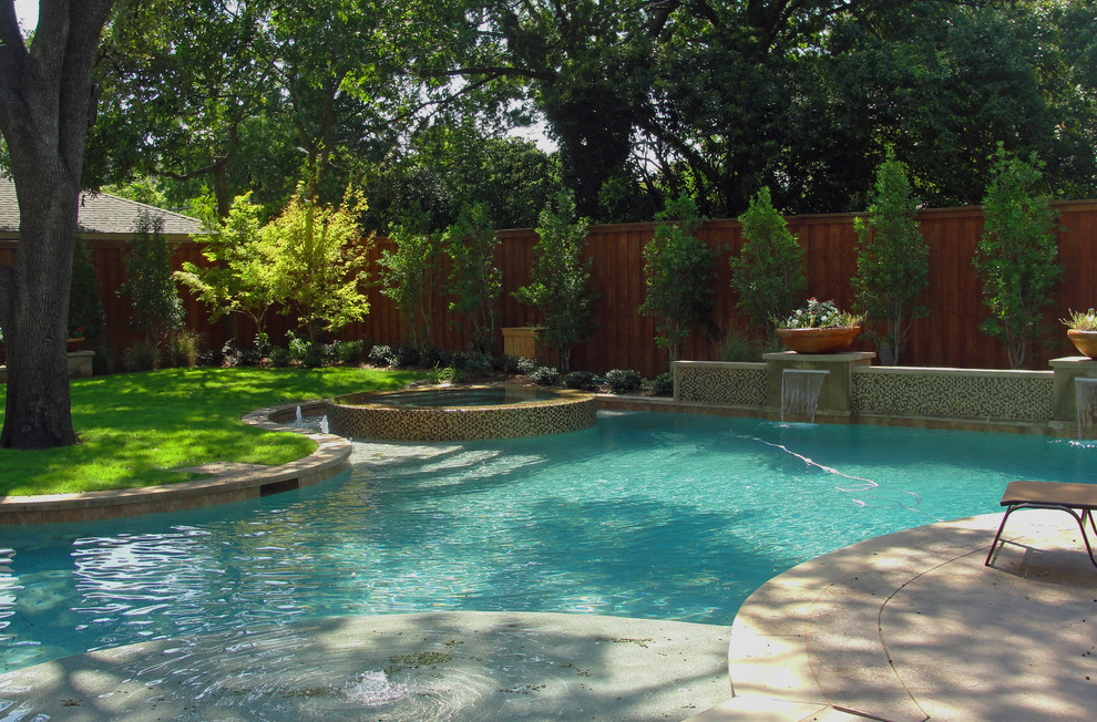 Foto de piscinas y jacuzzis alargados actuales grandes a medida en patio trasero con adoquines de hormigón