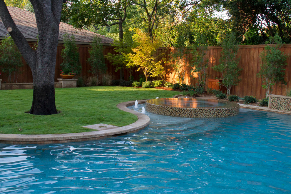 Modelo de piscinas y jacuzzis alargados actuales grandes a medida en patio trasero con adoquines de hormigón
