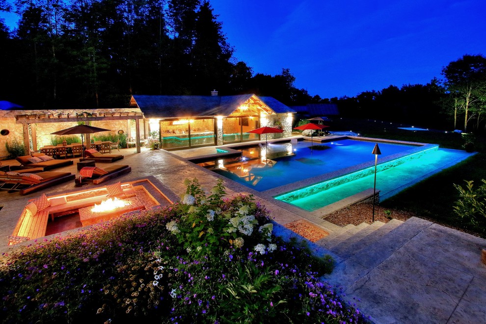 Foto di una grande piscina mediterranea rettangolare davanti casa con una dépendance a bordo piscina e cemento stampato
