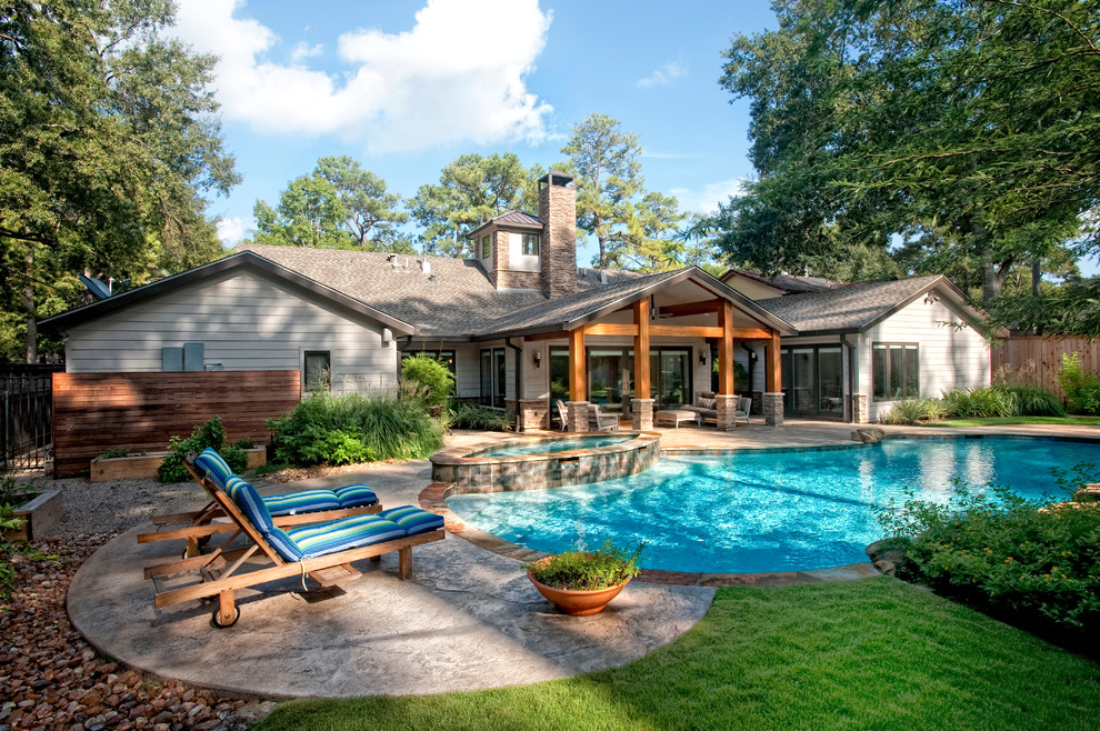 Photo of a classic back custom shaped swimming pool in Houston with concrete slabs and fencing.