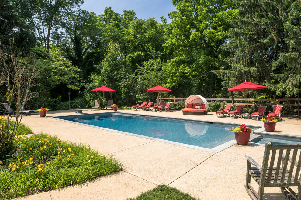 Foto de piscinas y jacuzzis alargados tradicionales grandes rectangulares en patio lateral con suelo de hormigón estampado